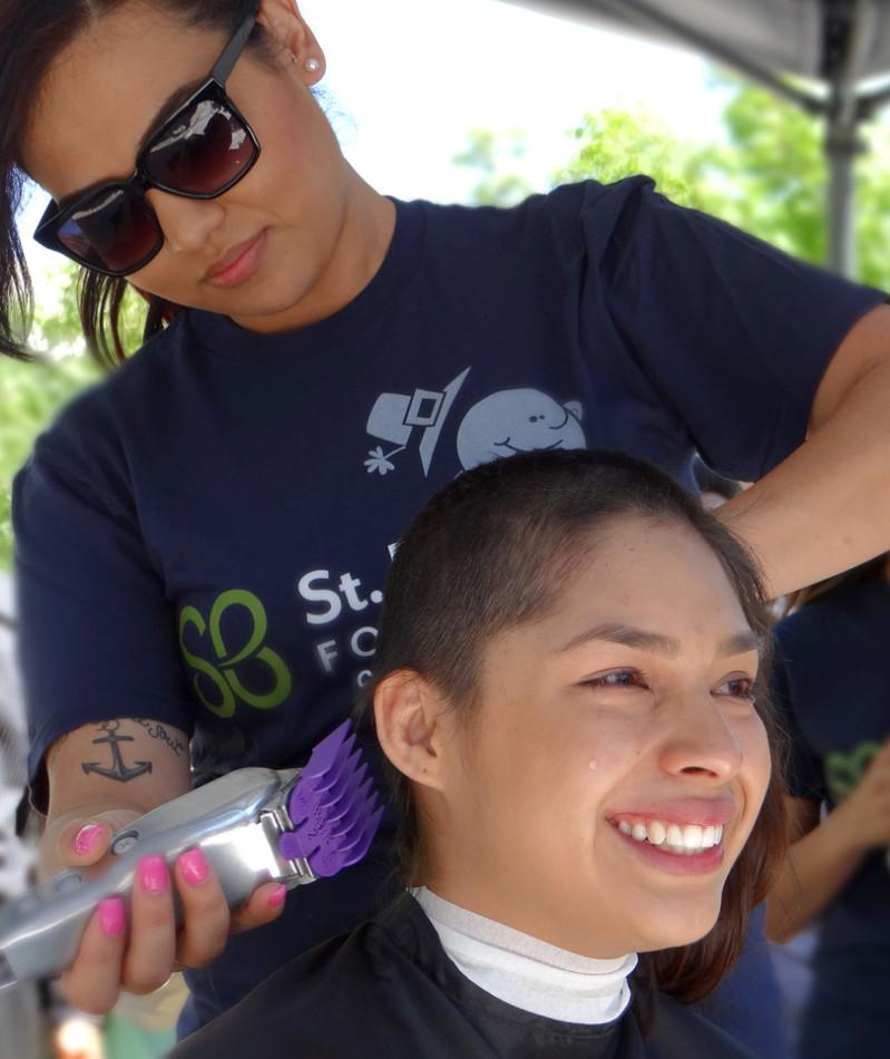 Karen Hernandez sheds a tear while getting her hair clipped in support of the St. Baldrick's Foundation.