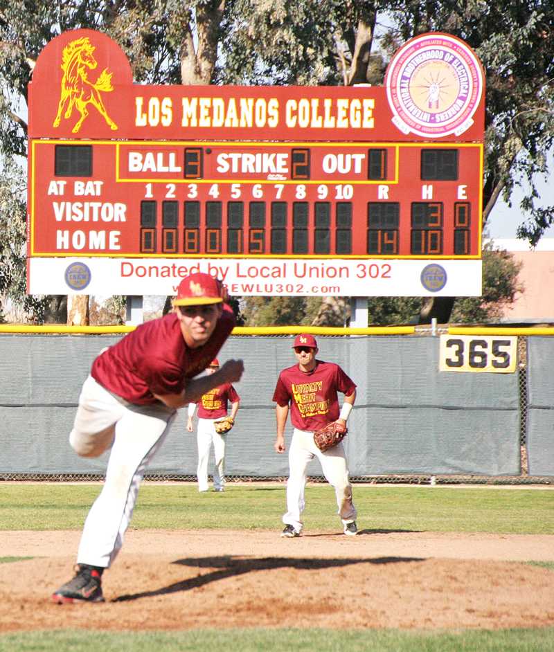 Jacob Jones delivers a pitch while his teammates get ready to field. Photo by Cathie Lawrence.