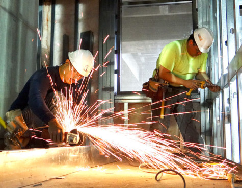 Sparks fly as Oscar Calvillo saws off a metal piece Feb. 12 inside the fourth floor construction zone that will be used for the proposed workroom in the Student Services building at the front of the College Complex.