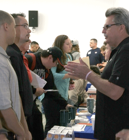 Albert Garcia and Don Cooper talk with Bill Mahoney about available jobs at Shell Corporation, one of the many companies present at the job fair.