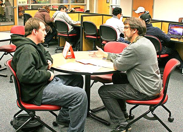 Professor Alex Sterling working with a student during Study Slam last year.