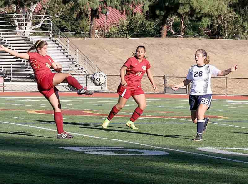 Amanda Forbes sends the ball back upfield with a big kick as teammate Paola Perez and Comet Gibsy Vilchis turn to follow the ball upfield.