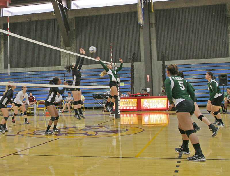 During the three-straight set victory Anna Vega leaps to block the shot by Luisa Delos Reyes at the net.