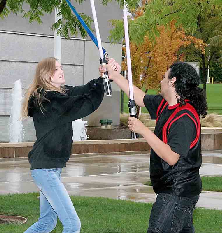 Haley Keller (left) and Giovanni Rajo engage in a lightsaber duel during the recent Free Hugs event. 