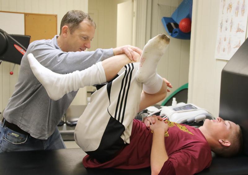 New+athletic+trainer+Brian+Powelson+stretches+out+LMC+first+baseman+Ryan+Welsh+to+help+avoid+a+leg+injury.