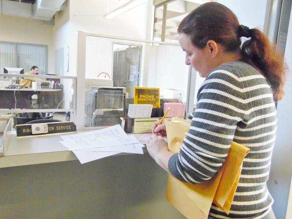 Instructional Assistant Jennifer Garcia fills out a request form at the new temporary location of the print shop.