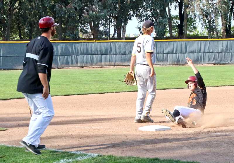 First baseman Ryan Welch slides safely into third base during the win over the College of Marin Tuesday, April 21 as Third Base Coach Brett Ringer watches the ball.