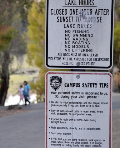 Signs posted by the entrance to the lake sate rules and campus safety tips for students and staff.