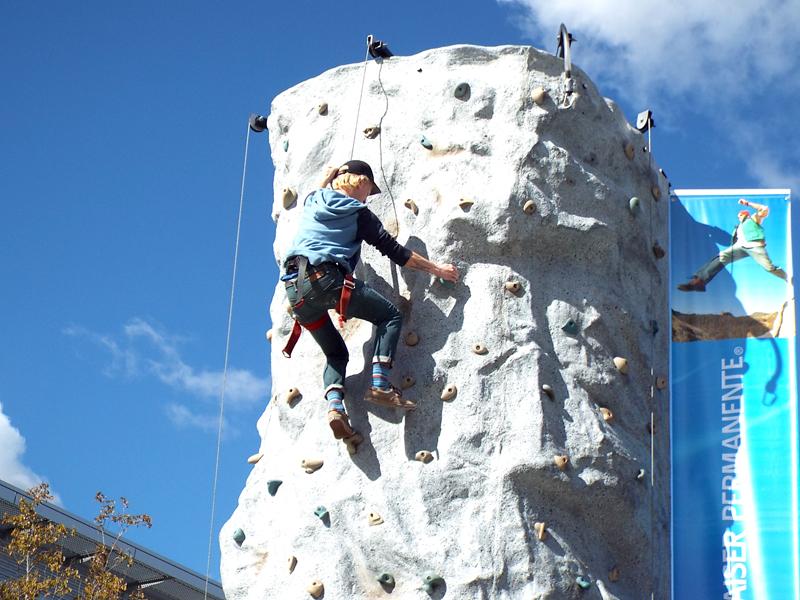 Chase Hendrickson-Jones of Inflatable Adventures climbs the medium difficulty section of the rock wall during the Kaiser Permanente Health and Wellness Festival Nov. 10.