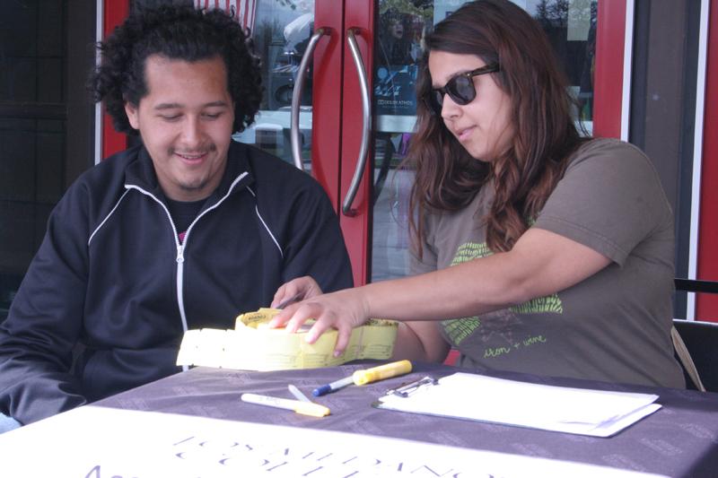 LMC Student Ambassadors Guadalupe Mauricio (left) and Taylor Gonzales hand out tickets at Maya Cinemas on Friday, Feb. 26.