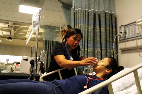 Melissa Cardenas gives a patient oxygen in the hospital area after the explosionh