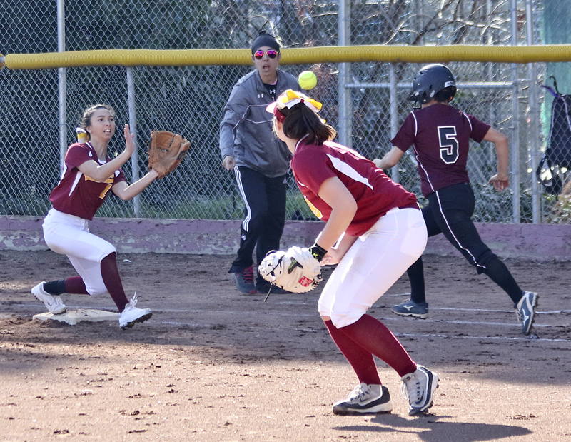 Mary Borlongan attempts to record an out reaching for the ball thrown by captain Brittany Bangert.