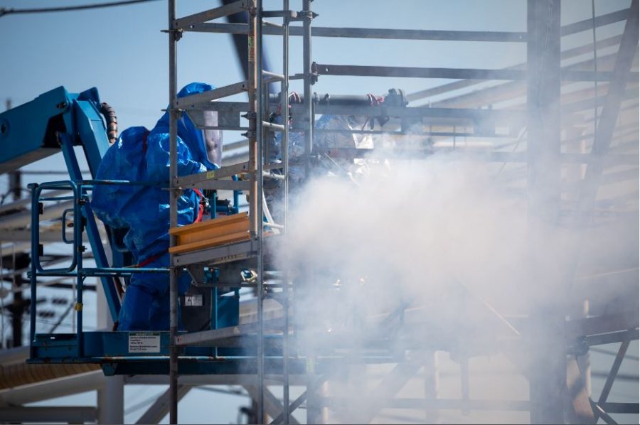 Corteva Agriscience workers in hazmat suits work to address mock gas leak emergency. 