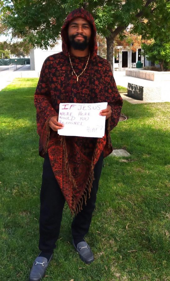 Terrance Henry Walker holding up a sign that reads If Jesus were here, would you recognize him? on campus.