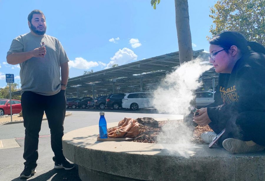 Hailey Finucane and Justin Ramey vape outside in parking Lot C at Los Medanos College.