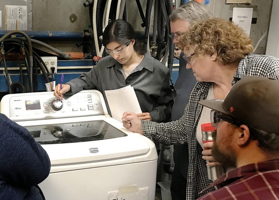 Student Marlene Lopez (left), Steve Lowery and Instructor Debra Winckler go over how to fix a washer.
