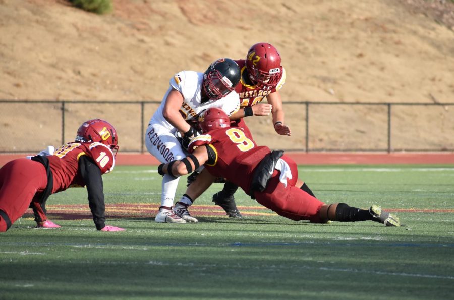 Line backer Heamasi Latu, No. 9, makes a tackle on a player from College of the Redwoods. 