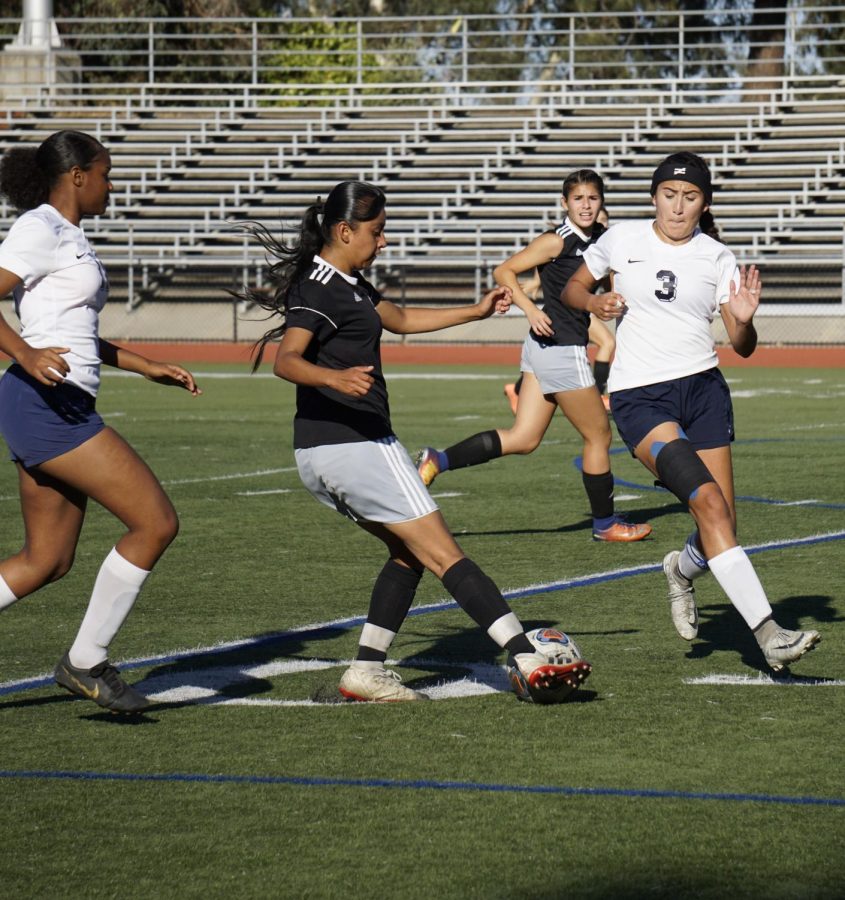 Litzy Ramirez, No. 10, dribbles around two defenders and makes a pass to Anissa Gomez, No. 12. 