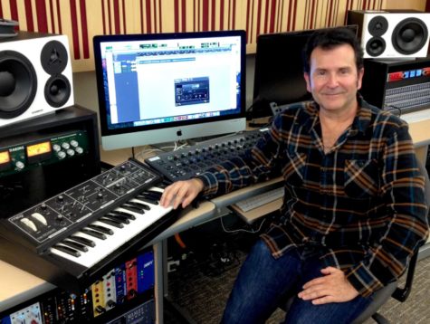 Len Haynes sits in his studio with music equipment.