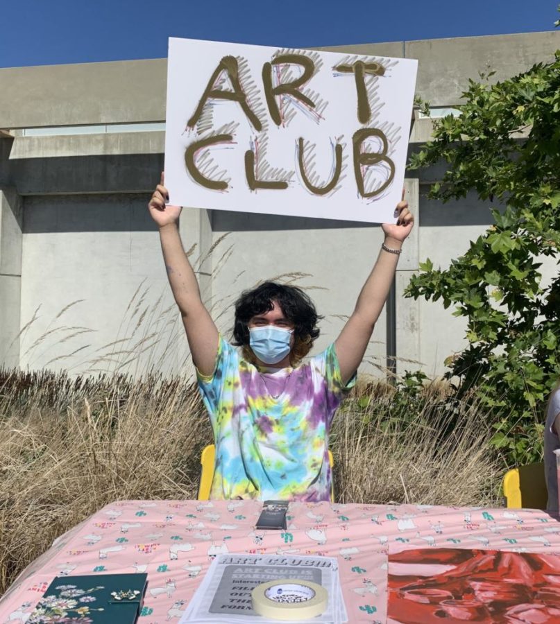Jacob Boyle holds up a sign for the Art Club.