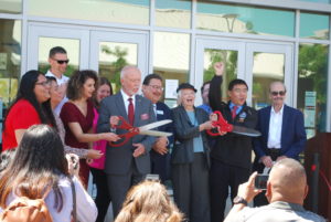 Mojdeh Mehdizadeh, Bob Kratochvil cut the ribbon with one pair of scissors while Judy Walters cuts the ribbon with another pair. 