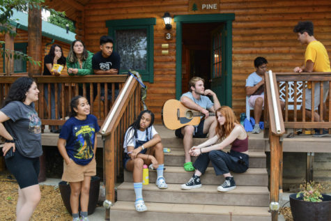 Honor students gather around the cabin to relax out on the porch