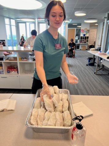 Student Life Associate Sophia hands out tacos to everyone in the student union building.