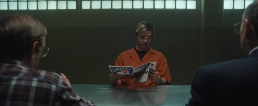 Jeffrey Dahmer (played by Evan Peters) reads a magazine while being interrogated.