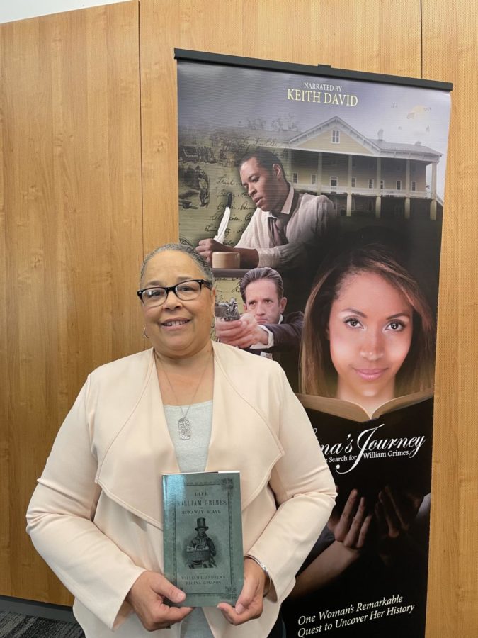 Author Regina Mason poses with her book, The life of William Grimes.