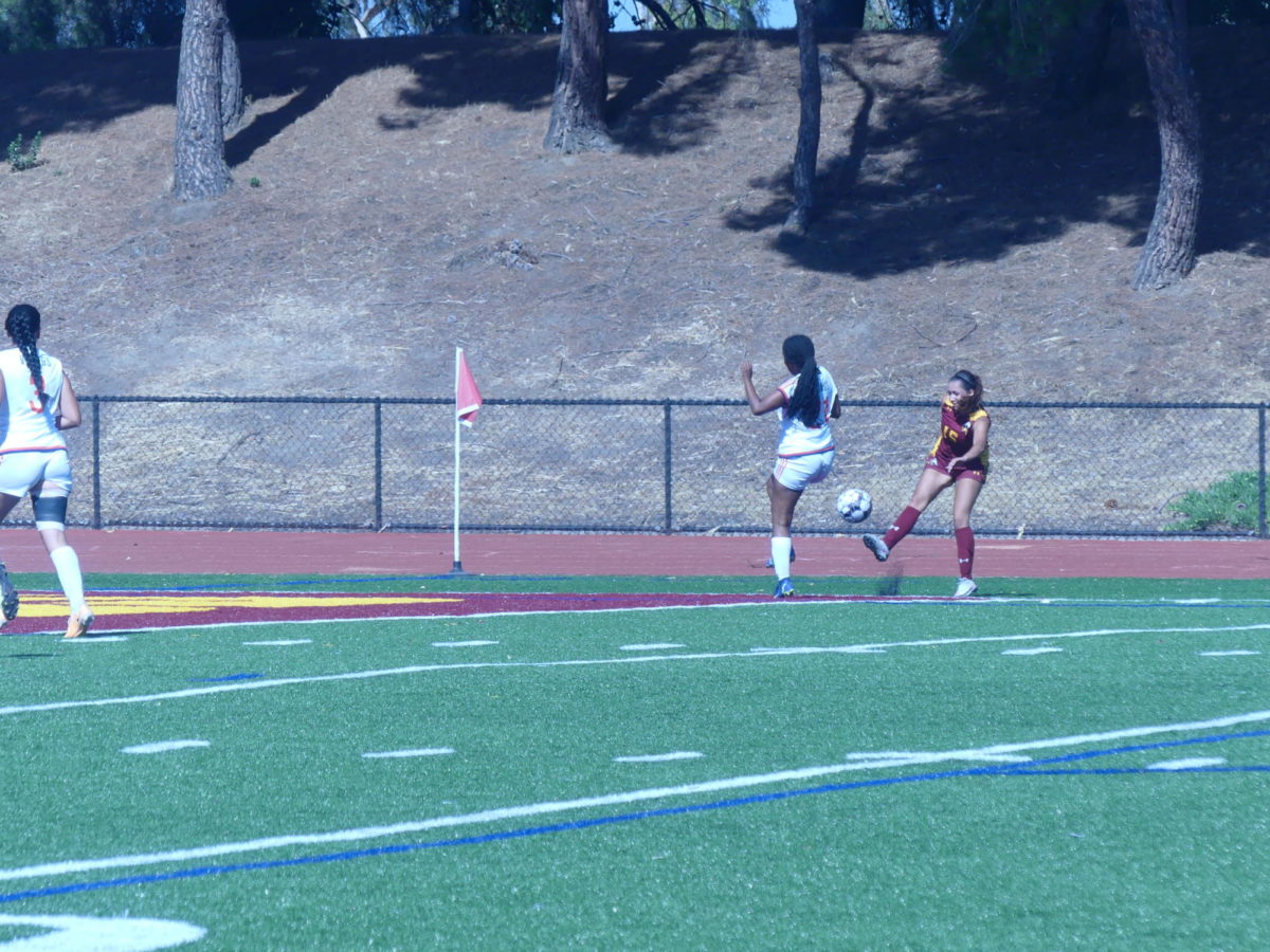 Emily Jimenez, No. 15 on the womens soccer team, kicks the ball toward the net for a teammate to score the goal.