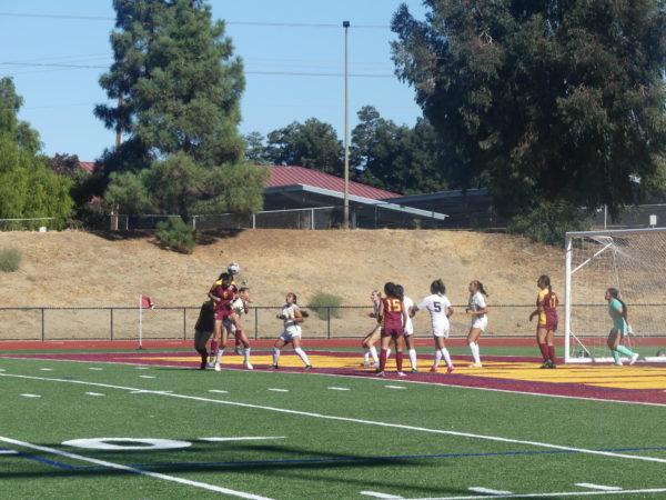 Los Medanos College Mustangs womens forward Briana Garcia shoots ball by her head toward the net in an attempt to score.