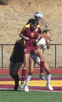 Los Medanos College Mustangs womens forward Briana Garcia shoots ball by her head toward the net in an attempt to score.
