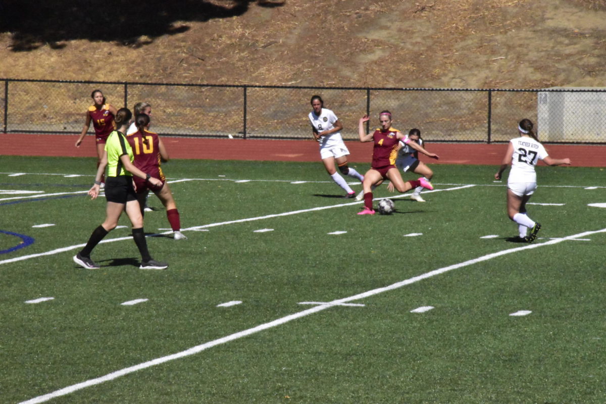 Olivia Kamm, No. 4 on the Mustangs, shoots the ball to the net attempting to score a goal.