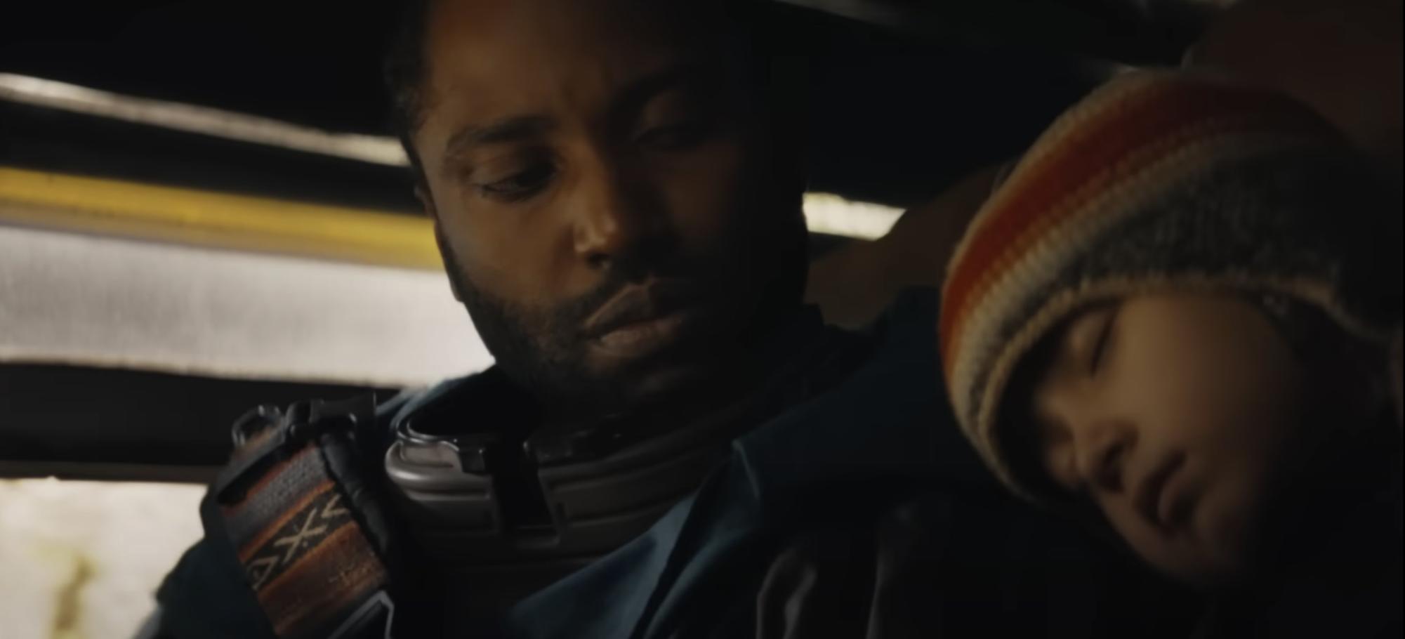 Sergeant Joshua Taylor, portrayed by John David Washington, watches as Alphie, portrayed by Madeleine Yuna Voyles, rests her head on his shoulder.