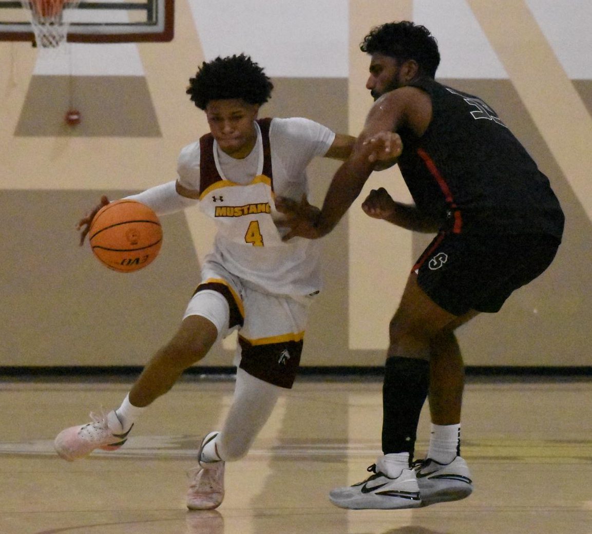 Los Medanos College Mustangs mens basketball player Ramon Bailey, No. 4, drives to the basket trying to get around the defender.