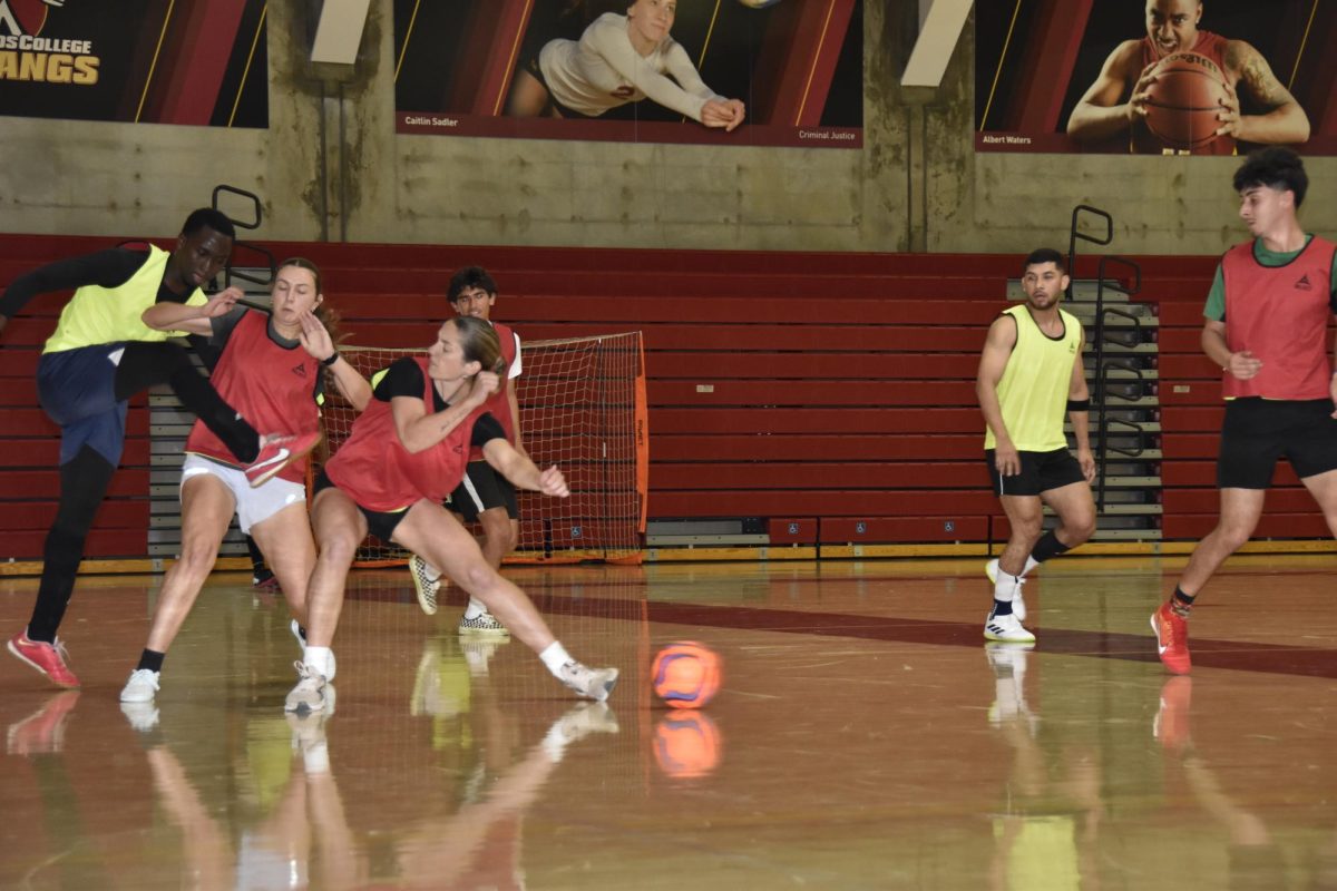 Three+players+fight+for+possession+of+the+ball+during+the+Futsal+tournament+Wednesday%2C+March+27.