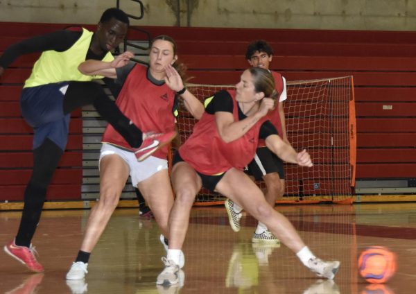 Three players fight for possession of the ball during the Futsal tournament Wednesday, March 27.