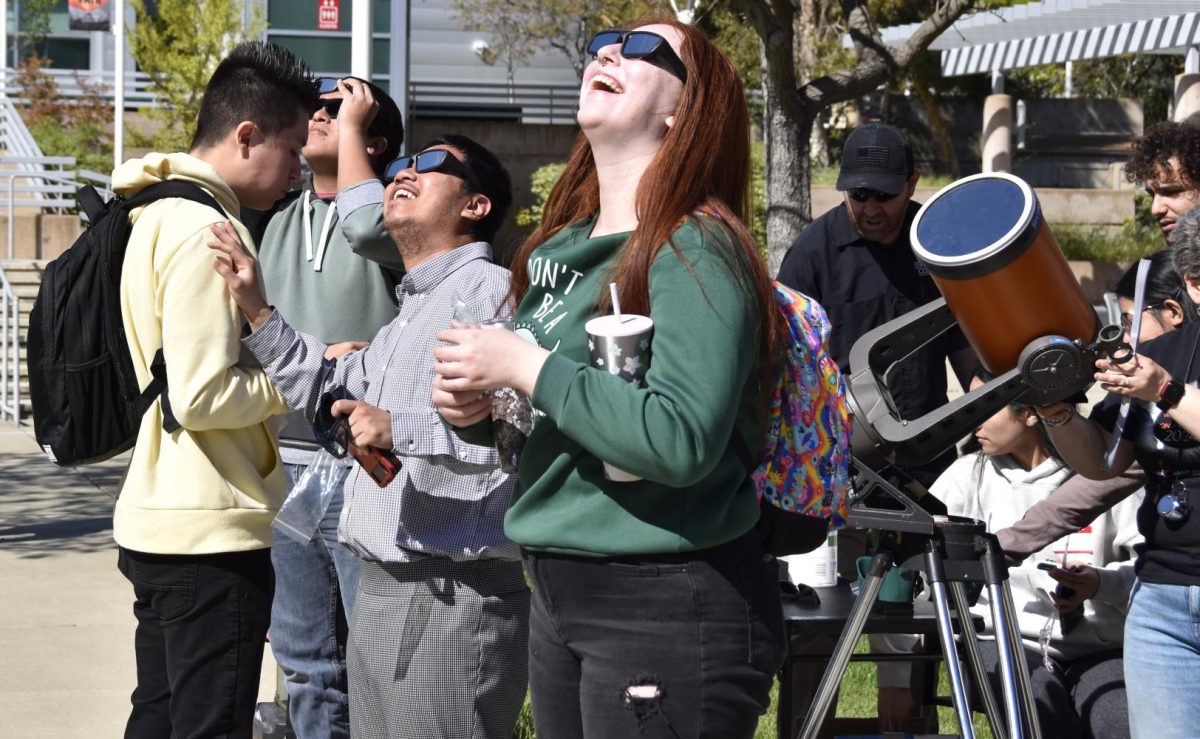 Students in the Los Medanos College quad gather to view the partial solar eclipse with their glasses Monday, April 8. 