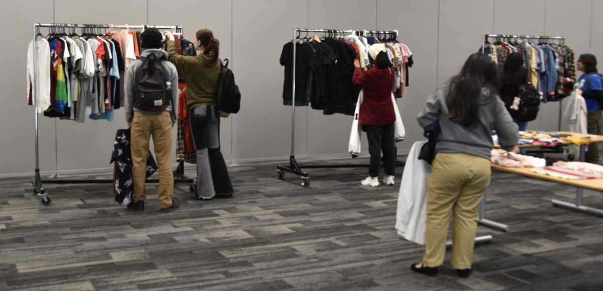 Students look through clothes that are available to purchase at thrift sale.