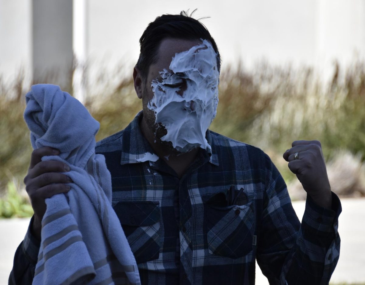 Political Science Professor Ryan Hiscocks receives whip cream to the face after collecting most votes for pie in the face.