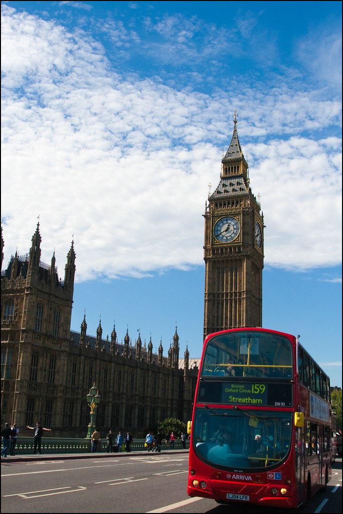London bus riding past the Big Ben clock tower.