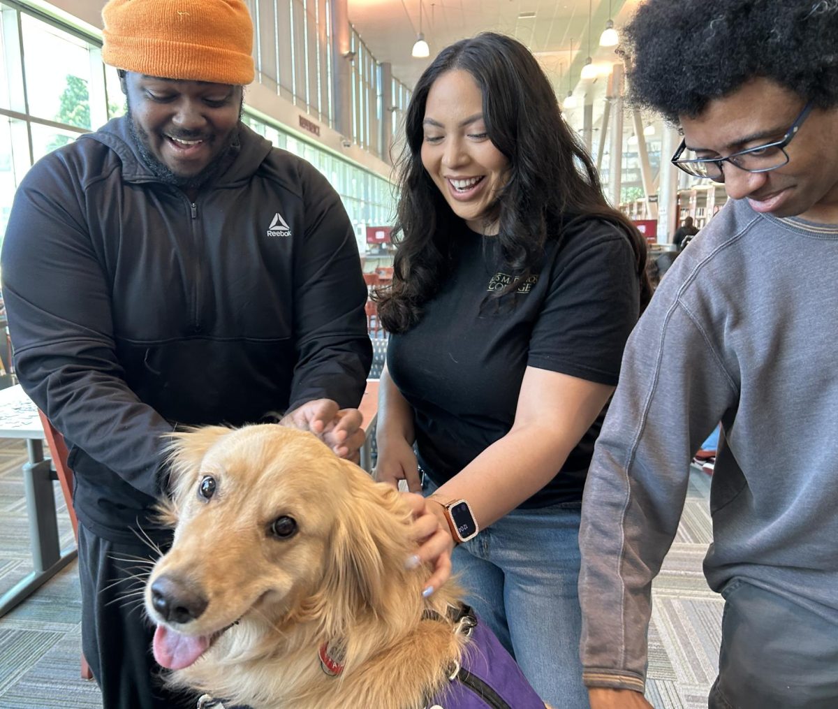 Isaiah Grogan, Cristina Navarrete, and Cameron Bluford pat Dolce, the Hug Pack Therapy dog