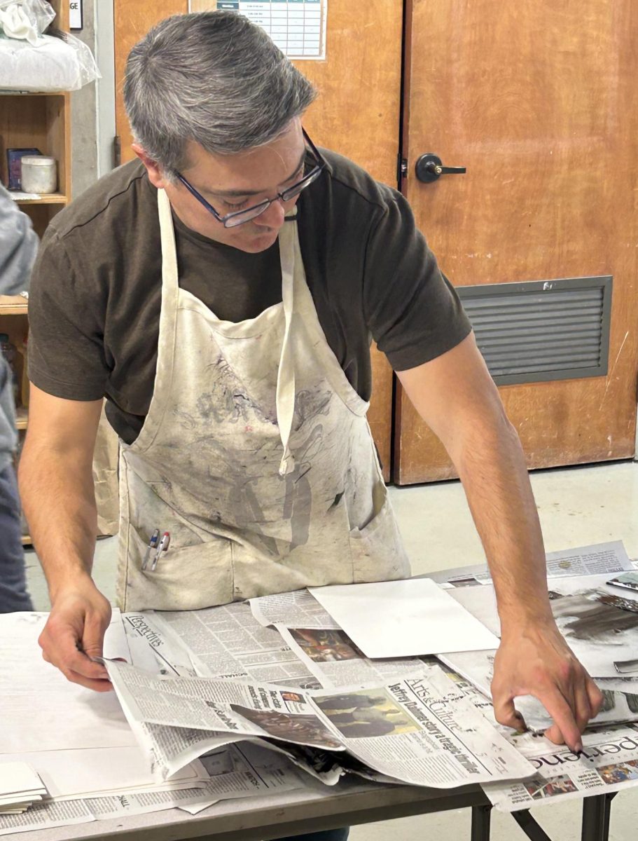 Professor Sanchez teaching hands-on in his intro to printmaking art class with his students