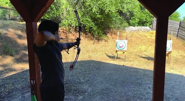 Honors student Dhanray Baladad takes aim of his bow and arrow during the archery activity held by Camp Tuolumne Trails staff during the retreat.  