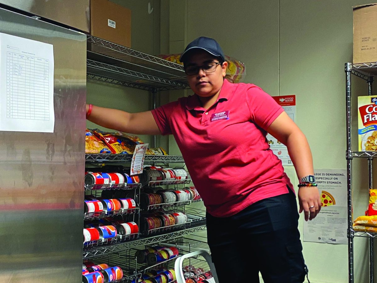 Pamela Peraria stocks food before the opening of the Marketplace.