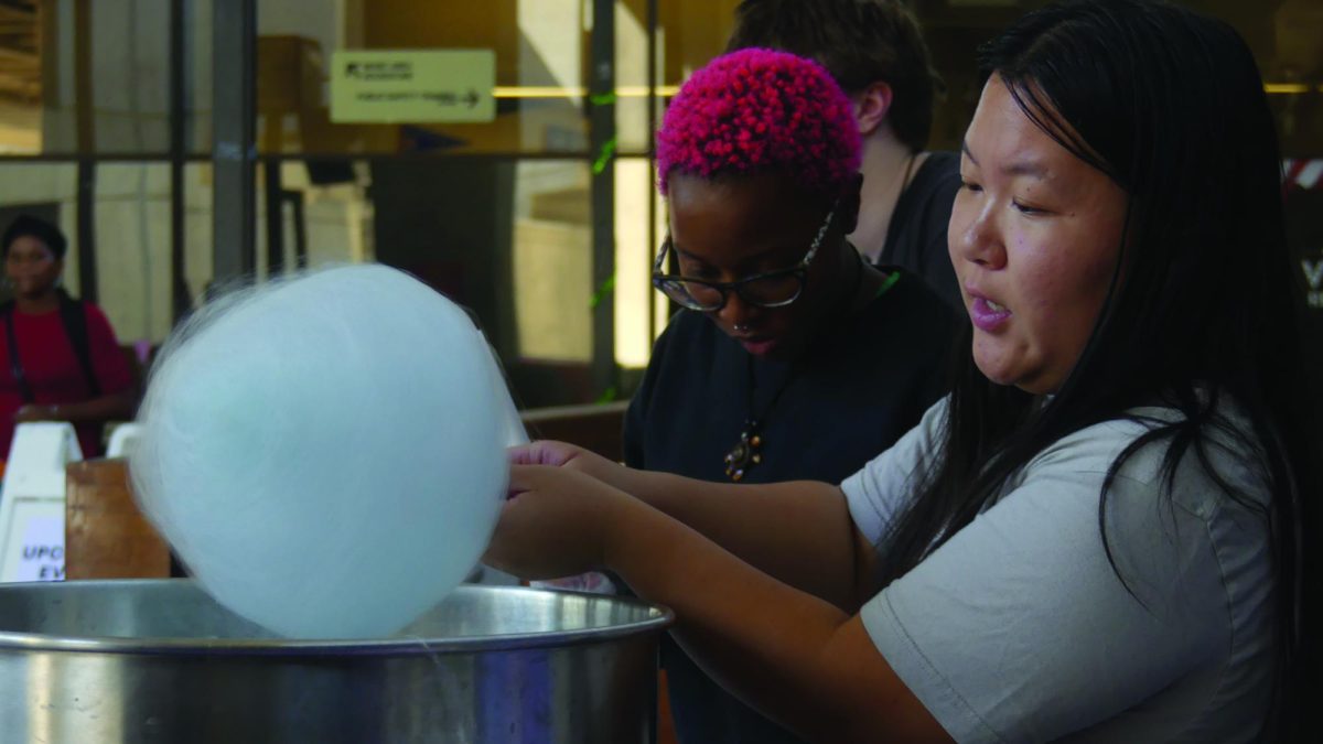 Philosophy Club passing cotton candy to students during the carnival in the College Complex Sept. 24.