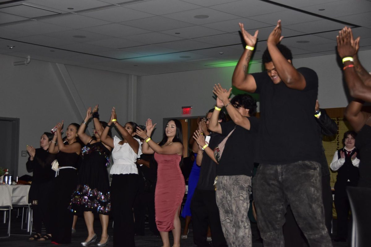 Puente Co-president Guadalupe Gama Gomez gathers with other Puentistas in clapping their hands to the music provided by the DJ at the Homecoming Dance in the Pittsburg Campus Student Union, Oct. 4.