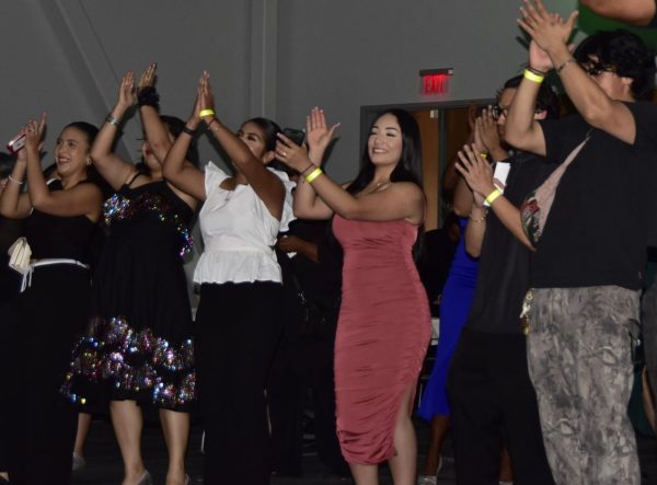 Puente Co-president Guadalupe Gama Gomez gathers with other Puentistas in clapping their hands to the music provided by the DJ at the Homecoming Dance in the Pittsburg Campus Student Union, Oct. 4.