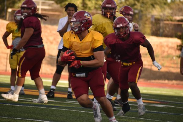 A Los medanos College Mustang receiver catches a pass and turns up field with determination to gain yards for an offesnsive drill at football practice, Oct. 23.