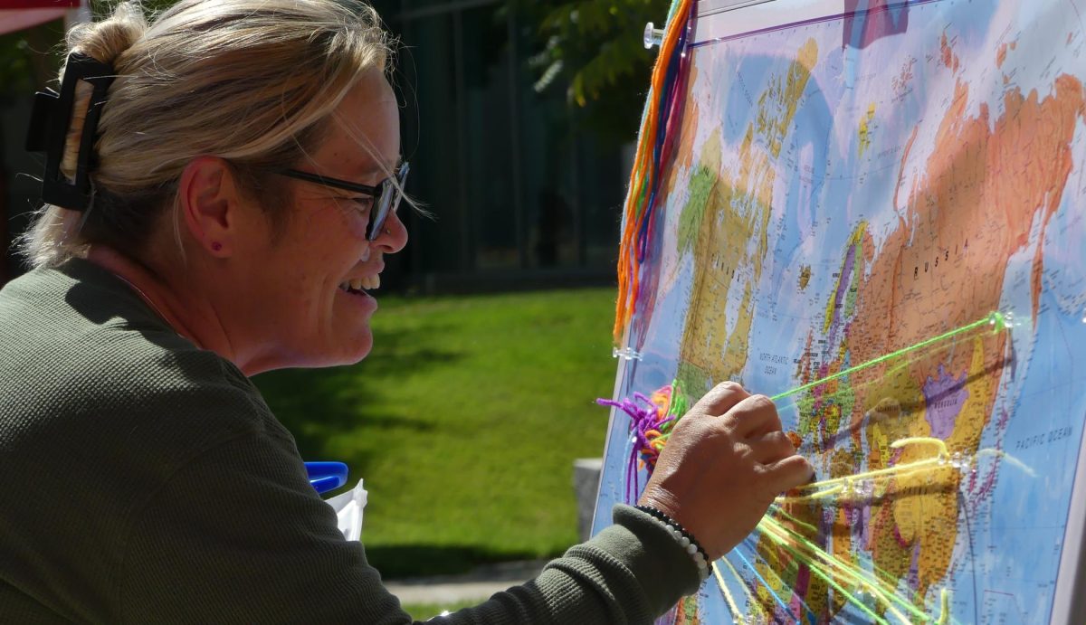 Vocational nursing student Elizabeth Ames studies the map to pin one of her places of belonging in Spain and Portugal. 